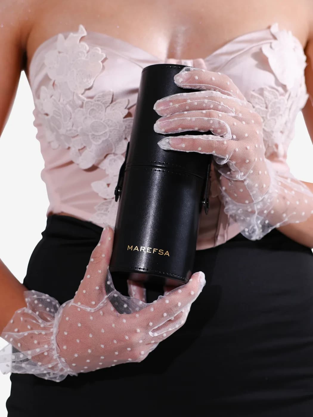 Gloved hands holding the black MAREFSA Signature Travel Case